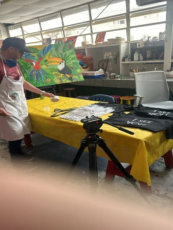 Mesa de produção com as camisetas da campanha I See You