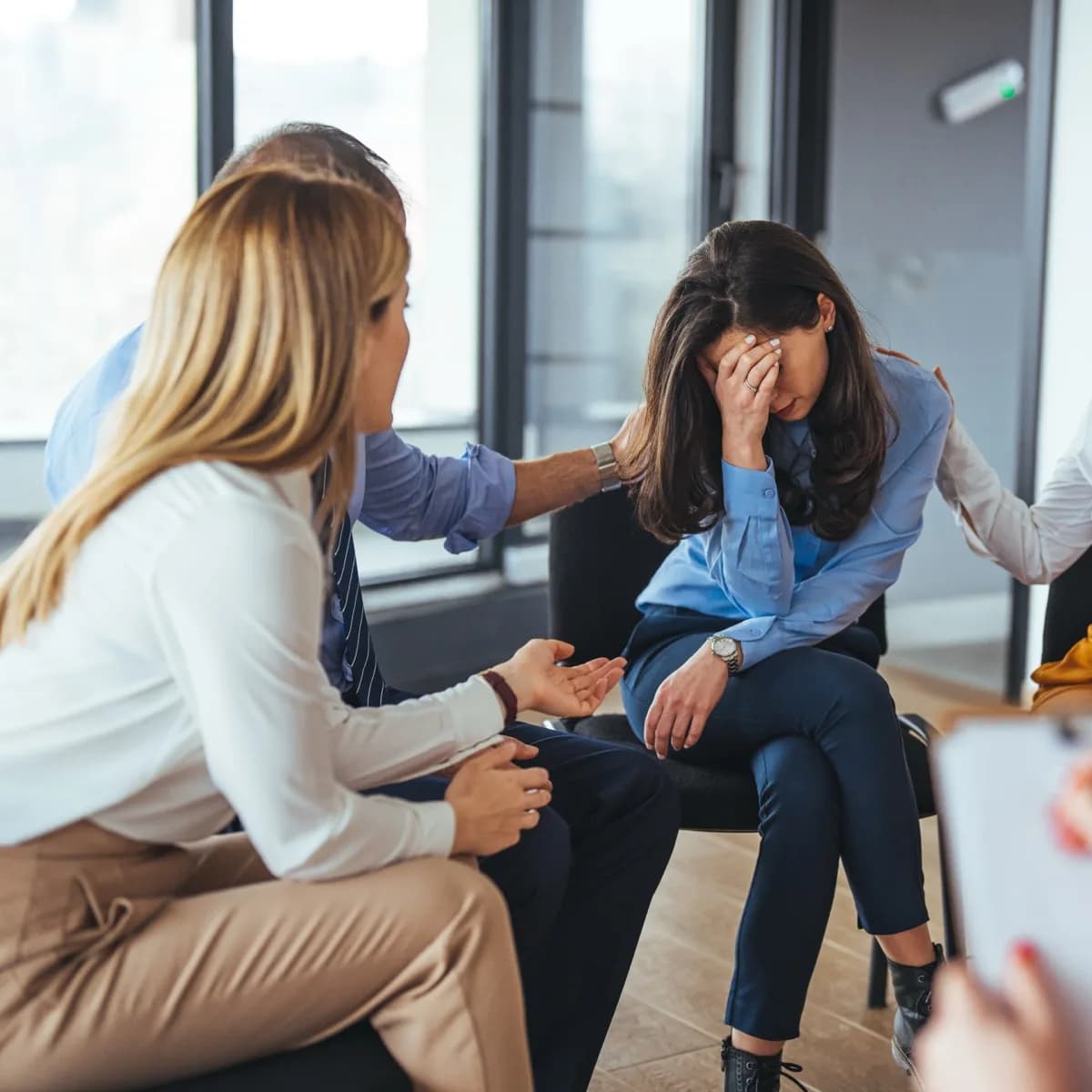 Equipe acolhendo um colega em um momento difícil no ambiente de trabalho